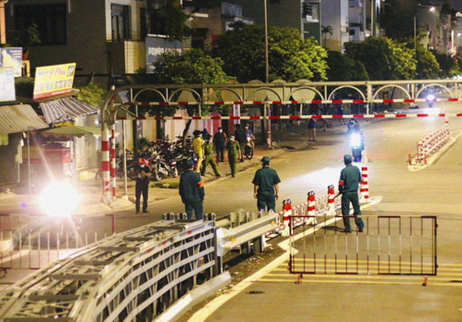 Officers guard a COVID-19 checkpoint in Ho Chi Minh City.